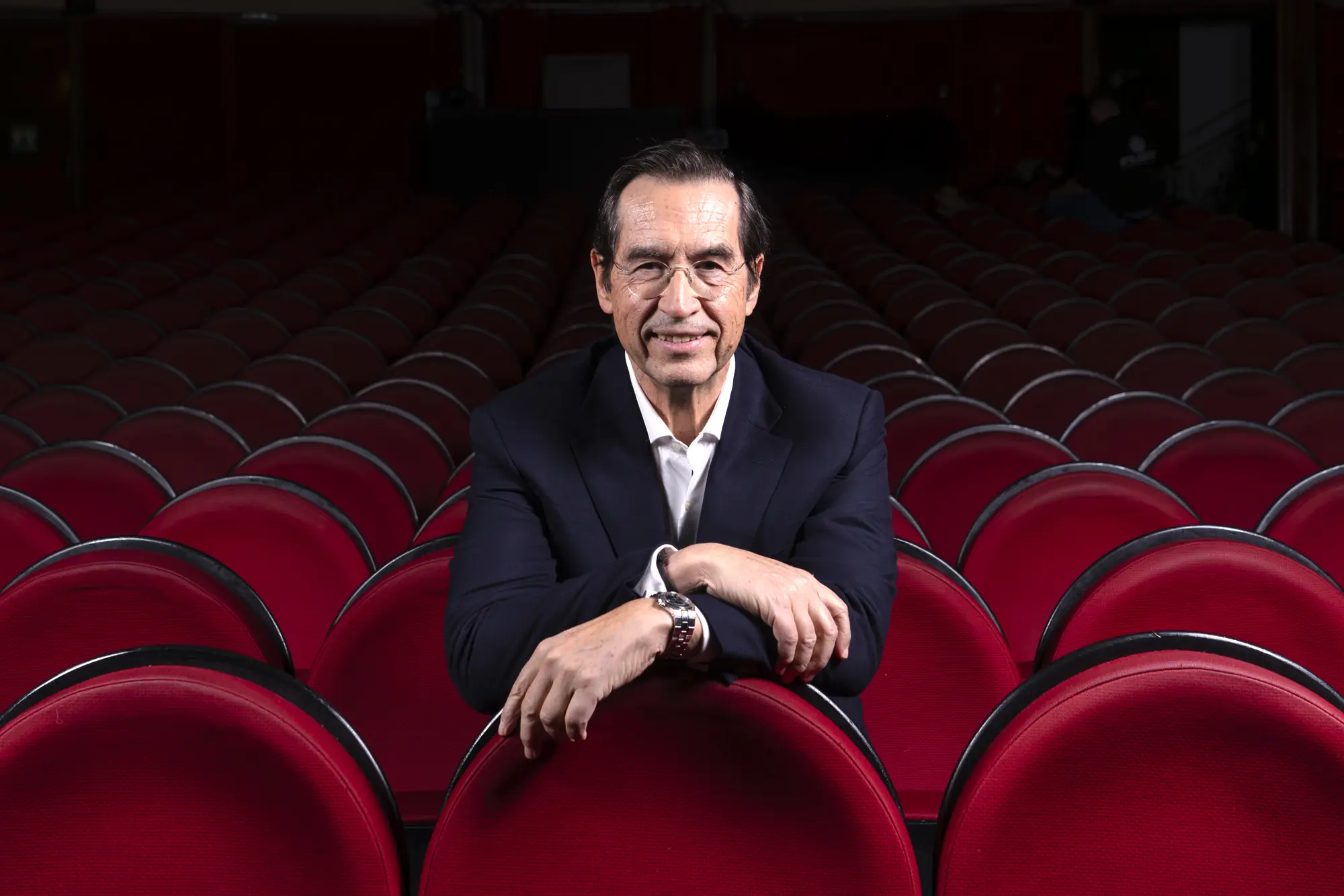 El Dr. Mario Alonso Puig sentado en el patio de butacas de un teatro